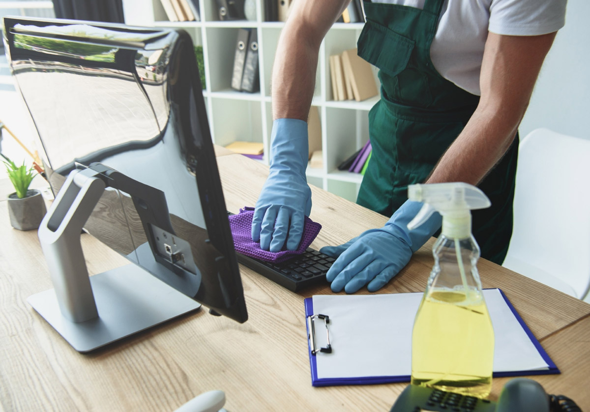 Professional cleaner wiping a computer keyborad